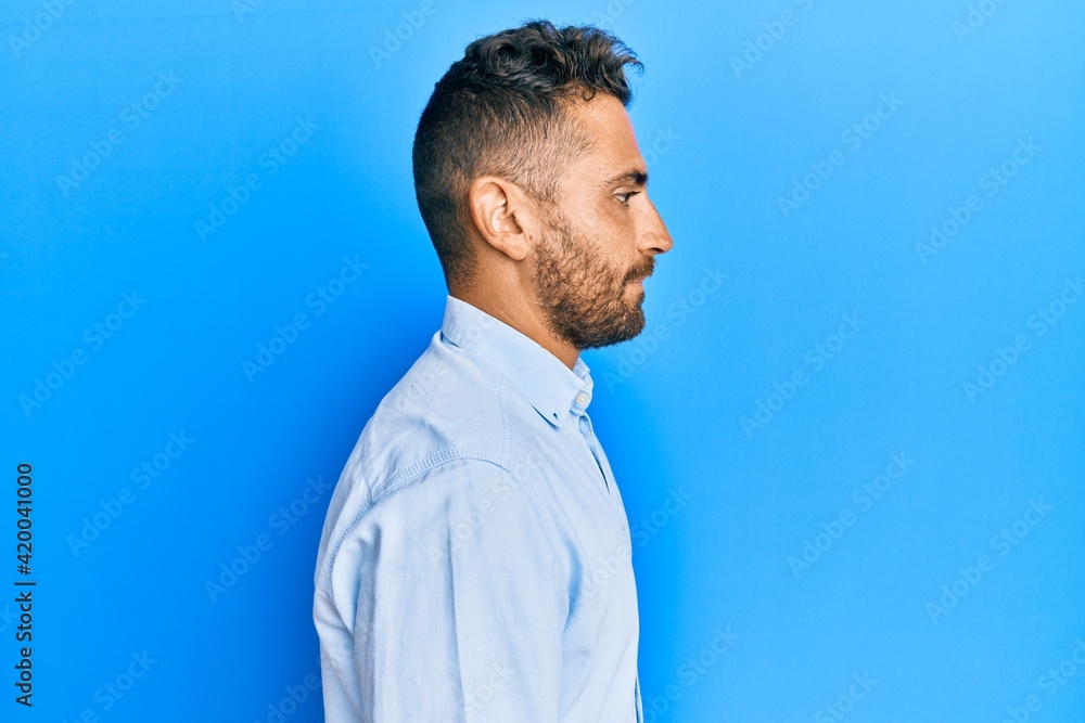 Handsome man with beard wearing casual clothes looking to side, relax profile pose with natural face with confident smile. Handsome man with beard wearing casual clothes looking to side, relax profile pose with natural face with confident smile.