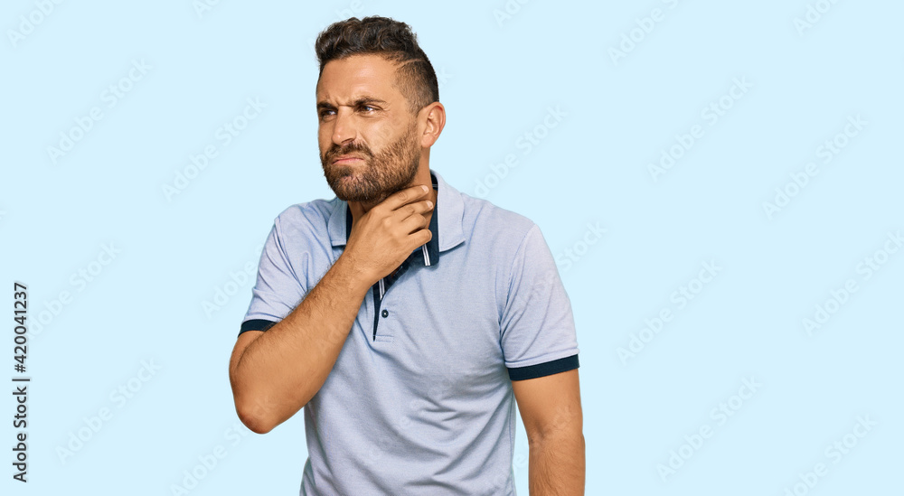 Handsome man with beard wearing casual clothes touching painful neck, sore throat for flu, clod and infection Handsome man with beard wearing casual clothes touching painful neck, sore throat for flu, clod and infection