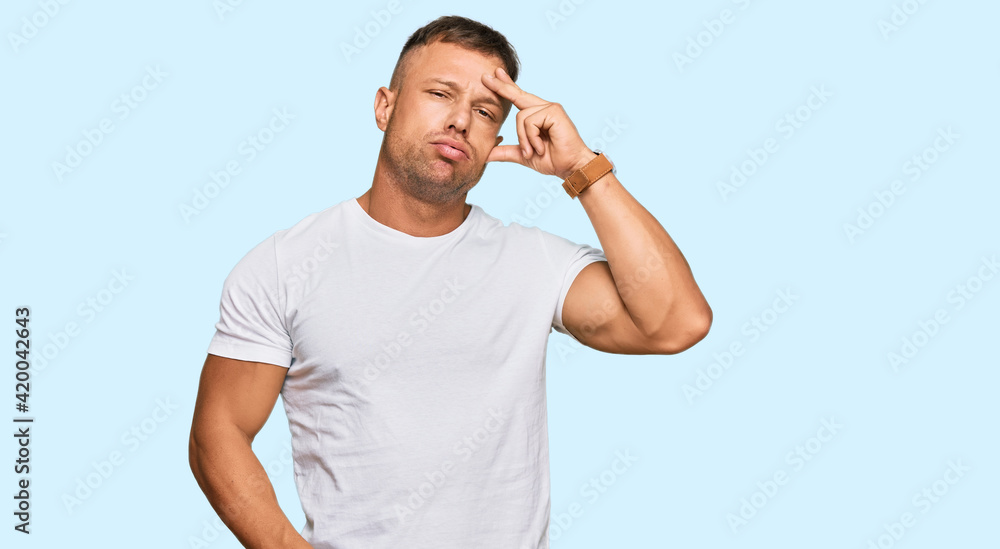 Handsome muscle man wearing casual white tshirt worried and stressed about a problem with hand on forehead, nervous and anxious for crisis Handsome muscle man wearing casual white tshirt worried and stressed about a problem with hand on forehead, nervous and anxious for crisis