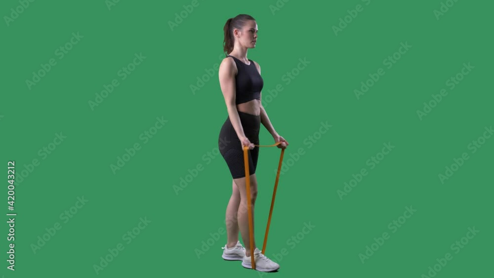 Side view of fit woman doing biceps exercise with resistance band. Full body on green screen chroma background. Side view of fit woman doing biceps exercise with resistance band. Full body on green screen chroma background.