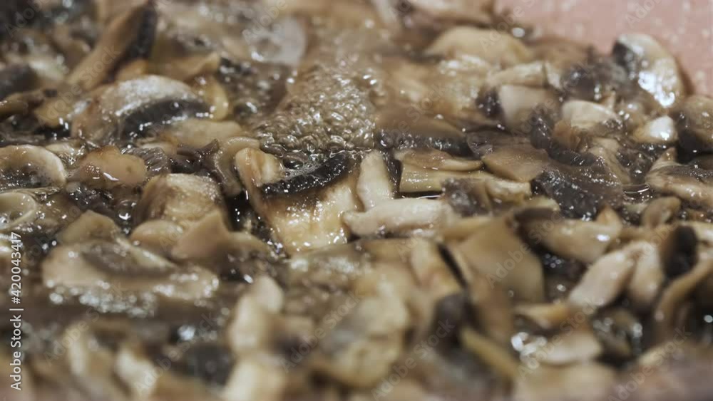Roasting Mushroom in Cooking Pan. Close Up Shot. Preperation for Dinner. Video Tutorial for Recipes. 4K UHD Resolution. Roasting Mushroom in Cooking Pan. Close Up Shot. Preperation for Dinner. Video Tutorial for Recipes. 4K UHD Resolution.