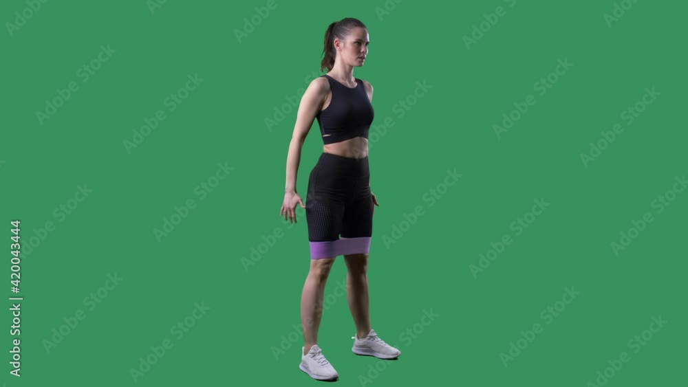 Side view of fitness woman doing squat exercise with resistance band. Full body on green screen chroma background. Side view of fitness woman doing squat exercise with resistance band. Full body on green screen chroma background.