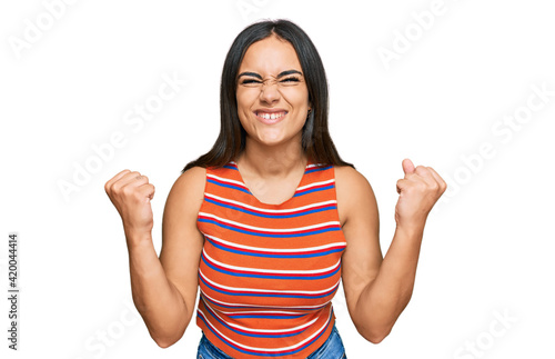 Young brunette woman wearing casual clothes celebrating surprised and amazed for success with arms raised and open eyes. winner concept.