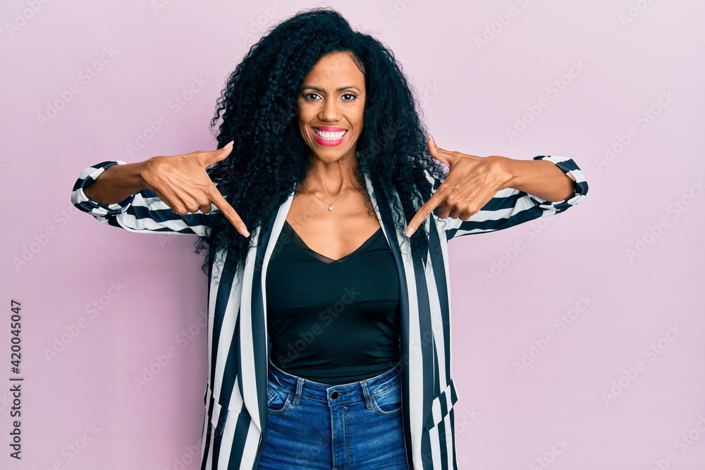 Middle age african american woman wearing casual clothes looking confident with smile on face, pointing oneself with fingers proud and happy.