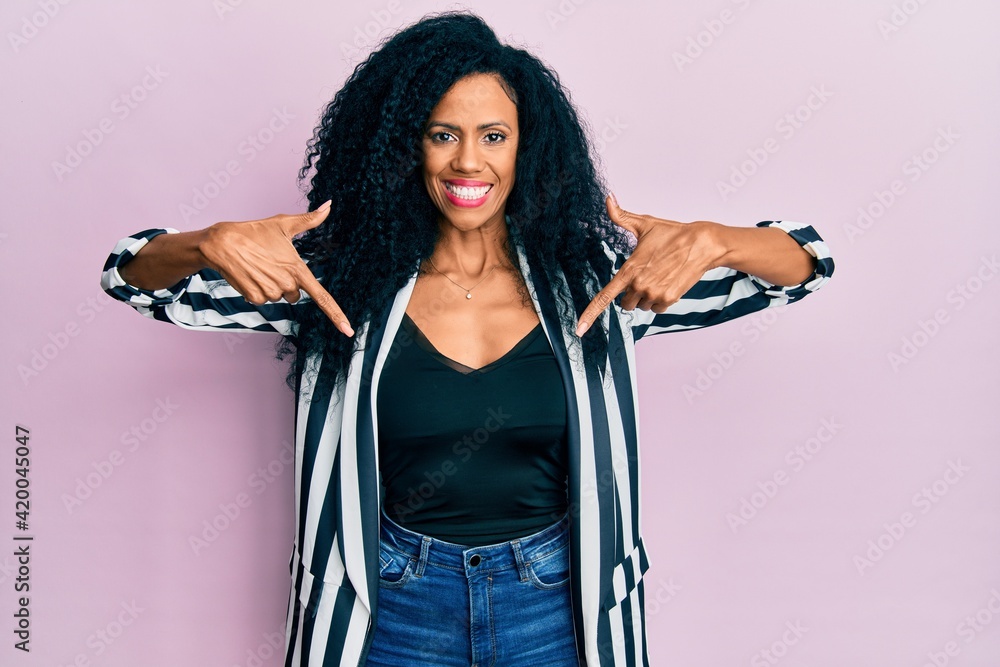 Middle age african american woman wearing casual clothes looking confident with smile on face, pointing oneself with fingers proud and happy. Middle age african american woman wearing casual clothes looking confident with smile on face, pointing oneself with fingers proud and happy.
