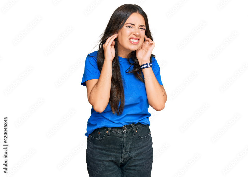 Beautiful brunette young woman wearing casual clothes covering ears with fingers with annoyed expression for the noise of loud music. deaf concept. Beautiful brunette young woman wearing casual clothes covering ears with fingers with annoyed expression for the noise of loud music. deaf concept.