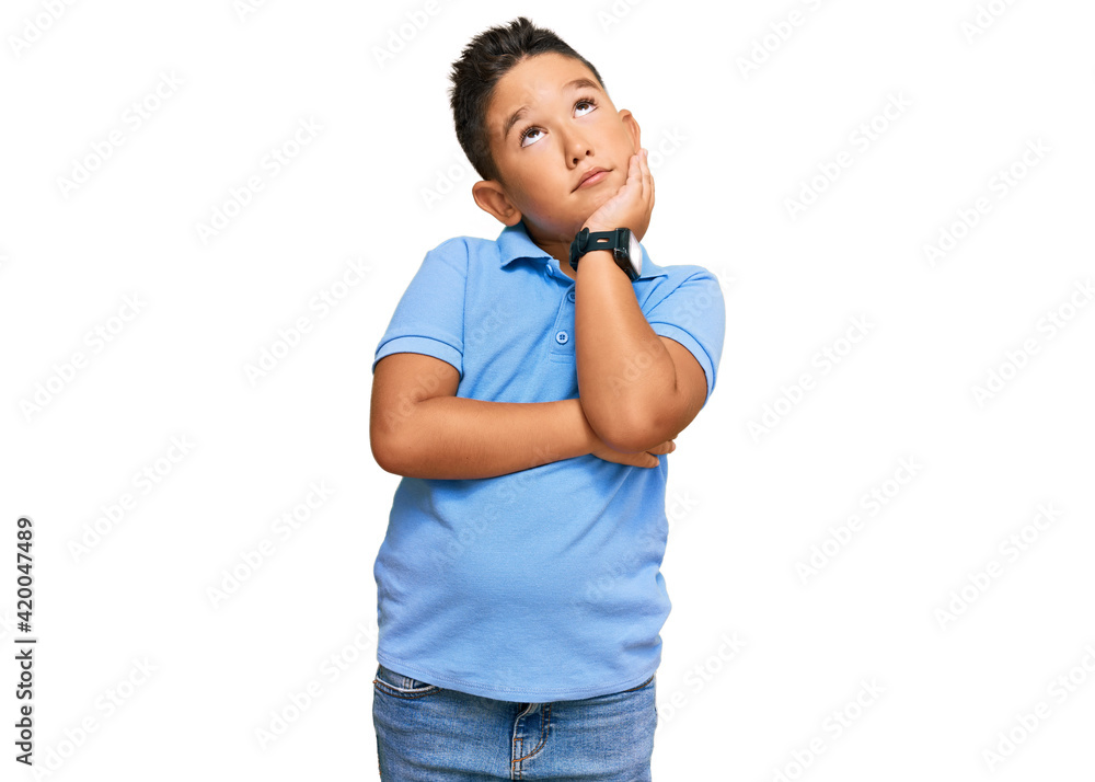 Little boy hispanic kid wearing casual clothes with hand on chin thinking about question, pensive expression. smiling and thoughtful face. doubt concept. Little boy hispanic kid wearing casual clothes with hand on chin thinking about question, pensive expression. smiling and thoughtful face. doubt concept.