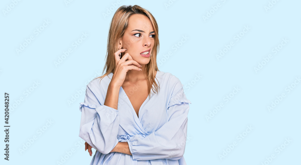 Beautiful blonde business woman wearing casual clothes serious face thinking about question with hand on chin, thoughtful about confusing idea Beautiful blonde business woman wearing casual clothes serious face thinking about question with hand on chin, thoughtful about confusing idea