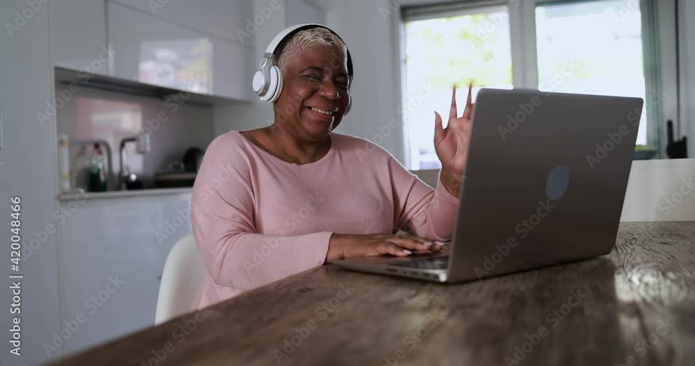 Senior african woman doing a video call using computer laptop at home Senior african woman doing a video call using computer laptop at home
