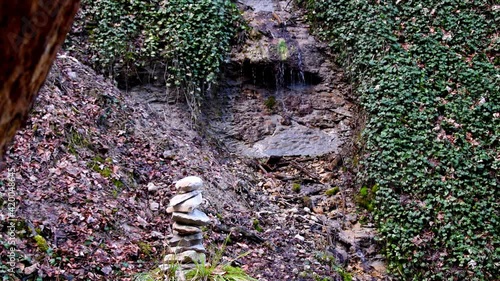 Zen stone pyramid with small water cascade in the background photo