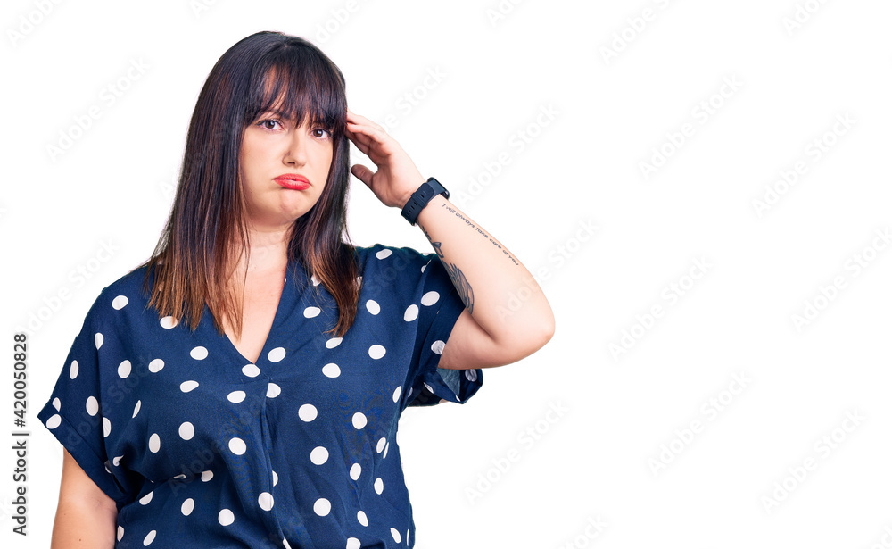 Young plus size woman wearing casual clothes worried and stressed about a problem with hand on forehead, nervous and anxious for crisis Young plus size woman wearing casual clothes worried and stressed about a problem with hand on forehead, nervous and anxious for crisis