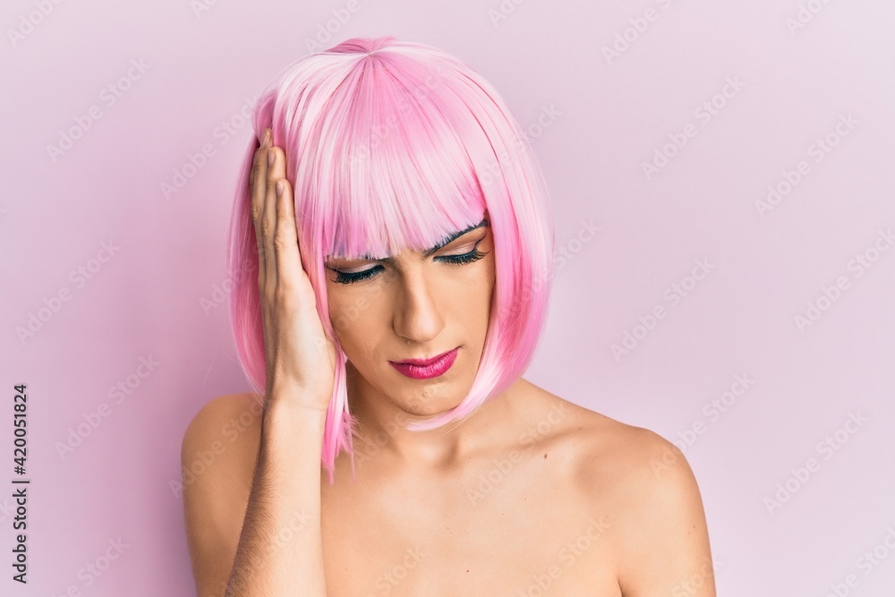 Young man wearing woman make up wearing pink wig thinking looking tired and bored with depression problems with crossed arms. Young man wearing woman make up wearing pink wig thinking looking tired and bored with depression problems with crossed arms.