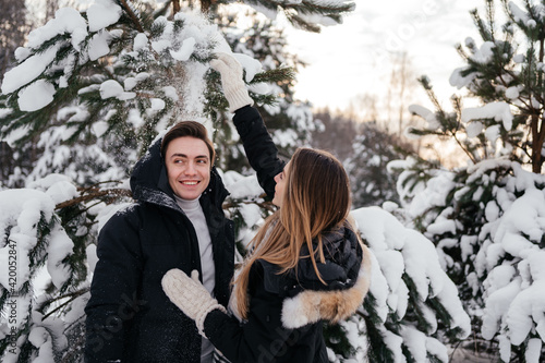 Young couple playing with snow in winter park