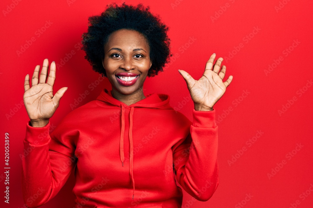 Young african american woman wearing casual sweatshirt showing and pointing up with fingers number ten while smiling confident and happy. Young african american woman wearing casual sweatshirt showing and pointing up with fingers number ten while smiling confident and happy.