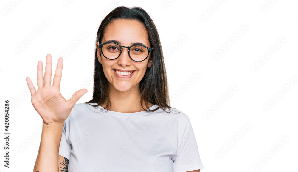 Young hispanic woman wearing casual white t shirt showing and pointing up with fingers number five while smiling confident and happy. Young hispanic woman wearing casual white t shirt showing and pointing up with fingers number five while smiling confident and happy.