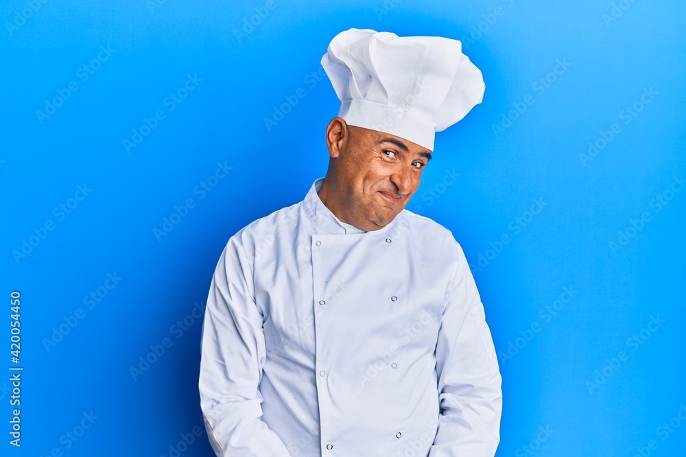 Mature middle east man wearing professional cook uniform and hat smiling looking to the side and staring away thinking. Mature middle east man wearing professional cook uniform and hat smiling looking to the side and staring away thinking.