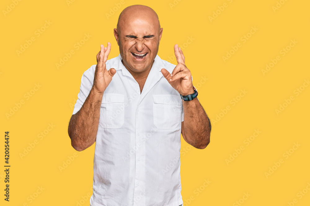 Mature middle east man with mustache wearing casual white shirt gesturing finger crossed smiling with hope and eyes closed. luck and superstitious concept. Mature middle east man with mustache wearing casual white shirt gesturing finger crossed smiling with hope and eyes closed. luck and superstitious concept.