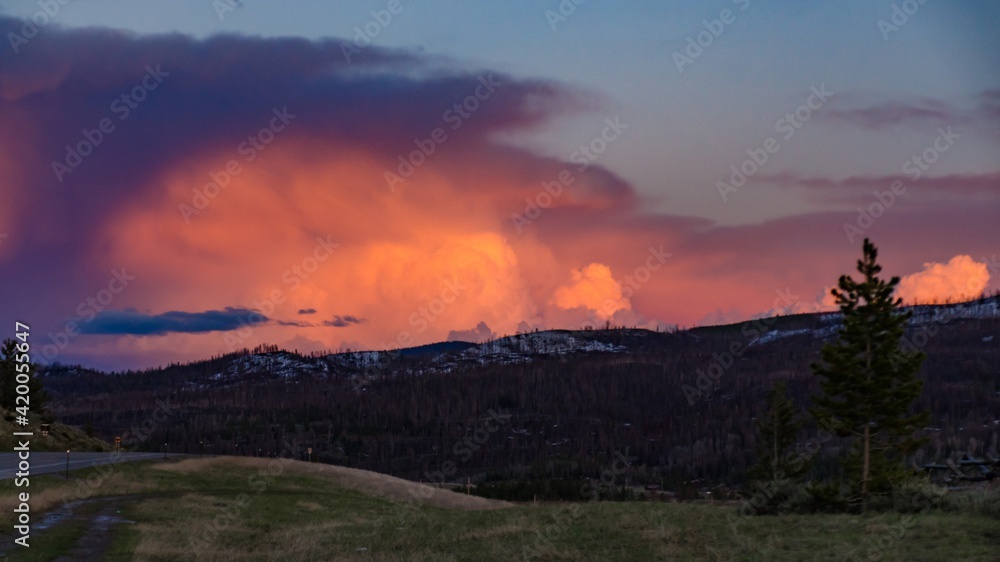 A beautiful red sunset over the mountains overgrown with coniferous forest. US