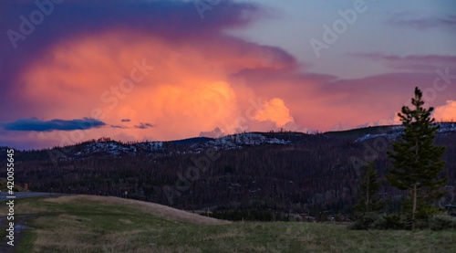 A beautiful red sunset over the mountains overgrown with coniferous forest. USA