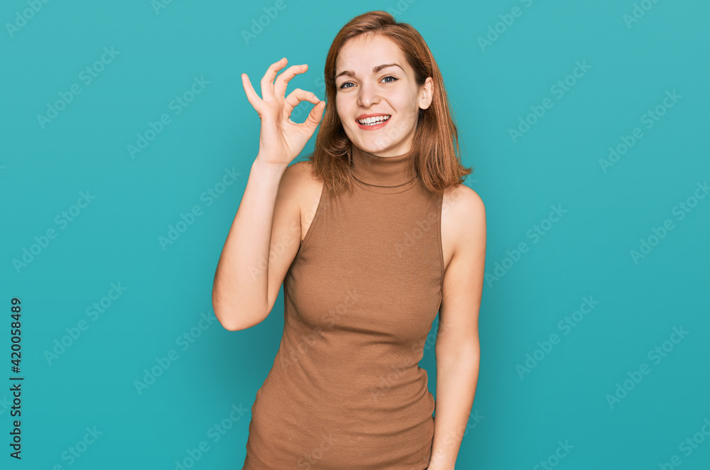 Fototapeta premium Young caucasian woman wearing casual clothes smiling positive doing ok sign with hand and fingers. successful expression.