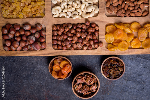 Dried fruits and nut mix on wooden board, top view. Healthy snack