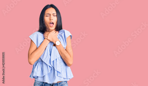 Young beautiful latin girl wearing casual clothes shouting suffocate because painful strangle. health problem. asphyxiate and suicide concept.