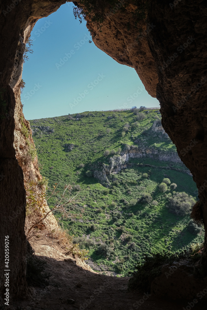 View of the Big Cave high above the narrow canyon of  Nahal [stream] dry bed, east of Upper Galilee, Northern Israel, south of Lebanon border, Israel.