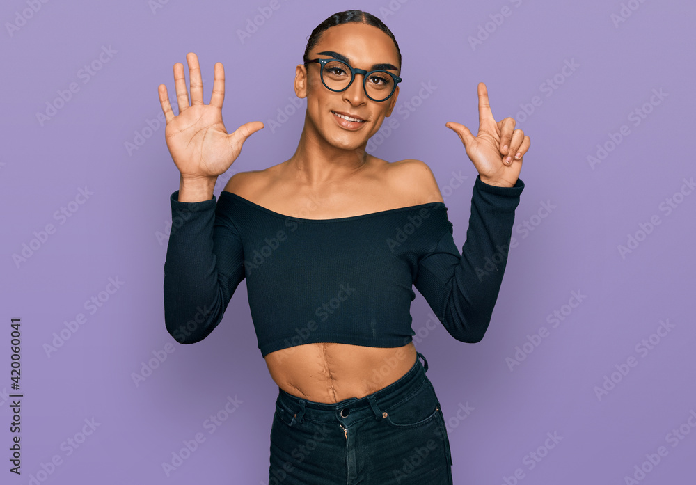 Obraz premium Hispanic transgender man wearing make up and long hair wearing women clothes showing and pointing up with fingers number seven while smiling confident and happy.