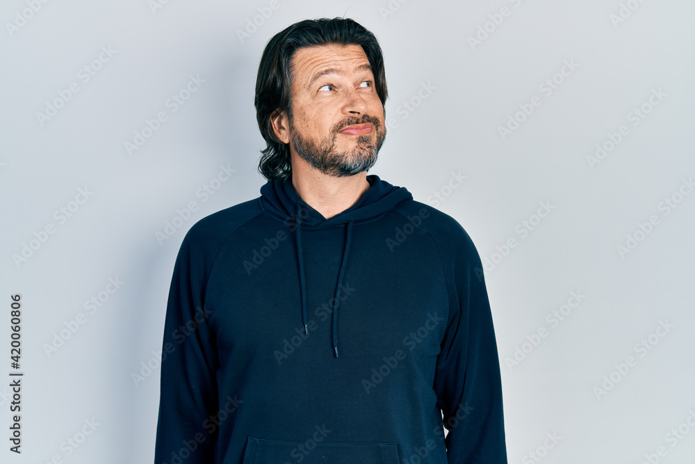 Middle age caucasian man wearing casual sweatshirt smiling looking to the side and staring away thinking. Middle age caucasian man wearing casual sweatshirt smiling looking to the side and staring away thinking.