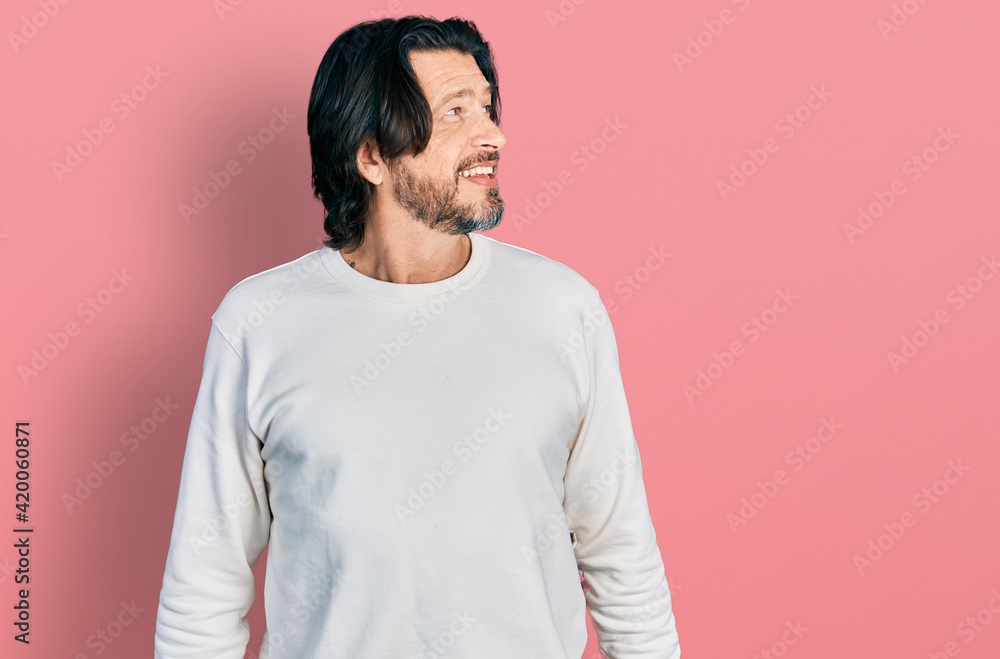 Middle age caucasian man wearing casual clothes looking away to side with smile on face, natural expression. laughing confident. Middle age caucasian man wearing casual clothes looking away to side with smile on face, natural expression. laughing confident.
