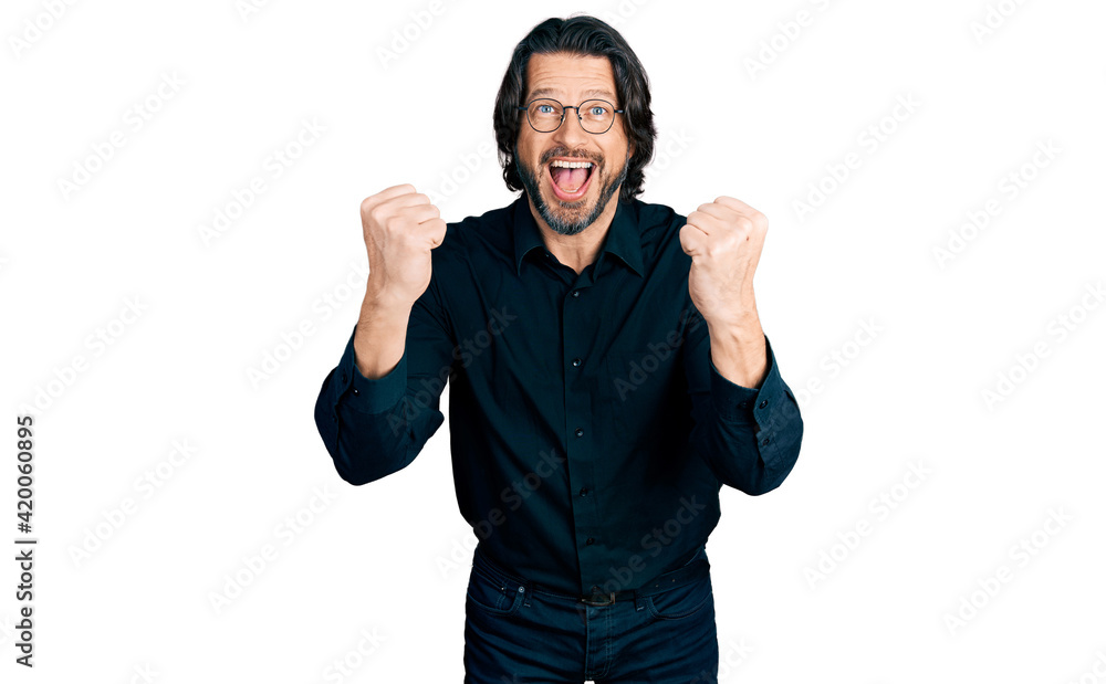 Fototapeta premium Middle age caucasian man wearing casual clothes and glasses celebrating surprised and amazed for success with arms raised and open eyes. winner concept.