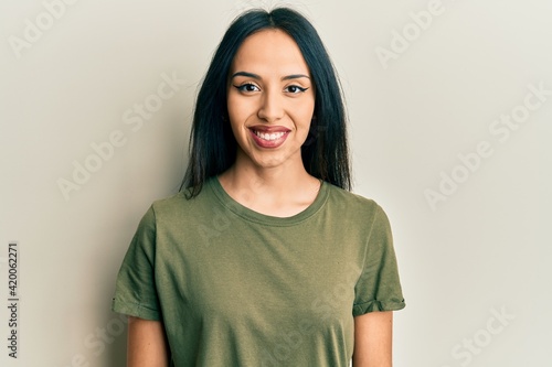 Young hispanic girl wearing casual t shirt with a happy and cool smile on face. lucky person.