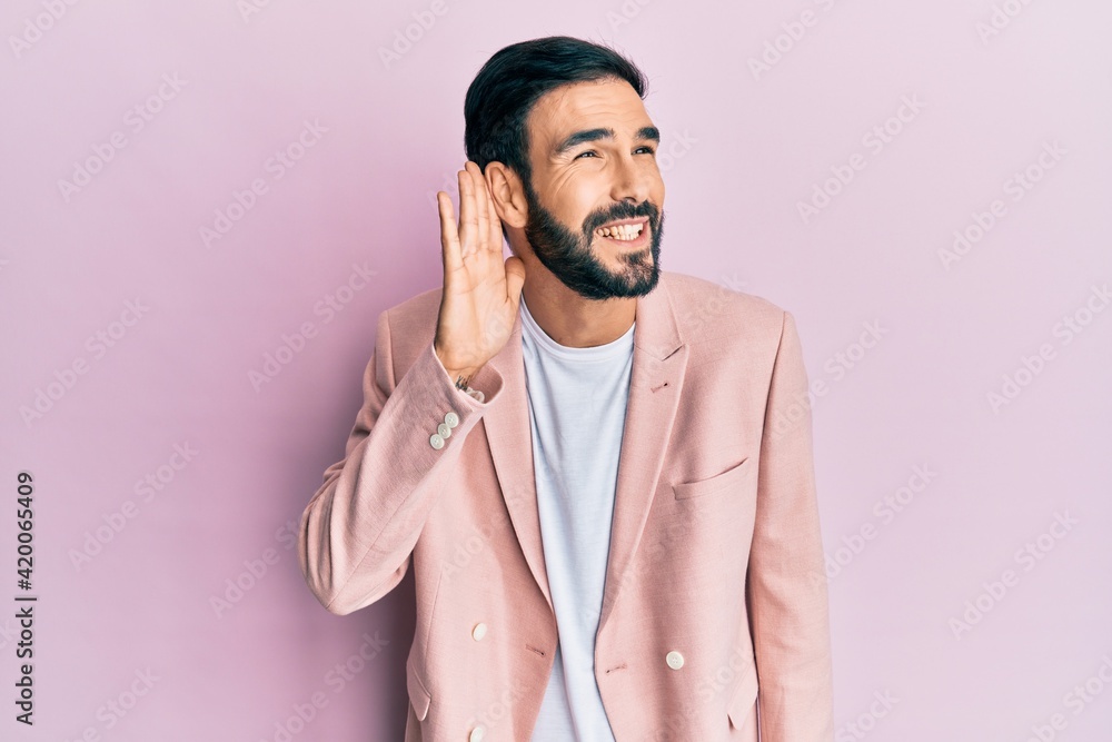 Young hispanic man wearing business jacket smiling with hand over ear listening an hearing to rumor or gossip. deafness concept. Young hispanic man wearing business jacket smiling with hand over ear listening an hearing to rumor or gossip. deafness concept.