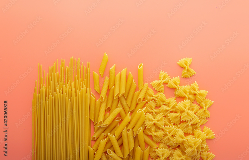 Pasta spaghetti penne farfalle on pink background Pasta spaghetti penne farfalle on pink background