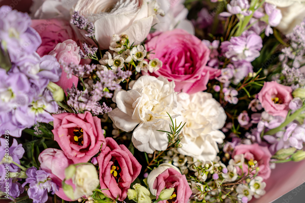 Bouquet of pink roses, alstroemeria flowers and orchids. Fresh summer flowers against gray background