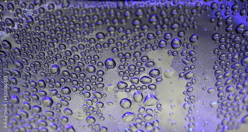 Fotografie purple large drops on a wet transparent surface as an abstract textured macro ba