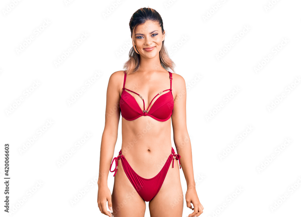 Naklejka premium Young beautiful woman wearing bikini with a happy and cool smile on face. lucky person.