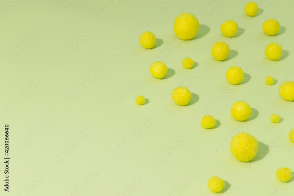 Small yellow balls of wool on a green background. Felting wool. Small yellow balls of wool on a green background. Felting wool.