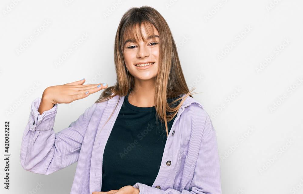 Teenager caucasian girl wearing casual clothes gesturing with hands showing big and large size sign, measure symbol. smiling looking at the camera. measuring concept.