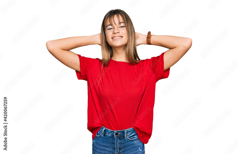 Teenager caucasian girl wearing casual red t shirt relaxing and stretching, arms and hands behind head and neck smiling happy Teenager caucasian girl wearing casual red t shirt relaxing and stretching, arms and hands behind head and neck smiling happy