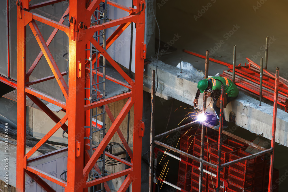 Naklejka premium Worker are working cutting or welding steel structure, Safety uniform and work planing in workplace, Construction site, Development land and residential building in city.
