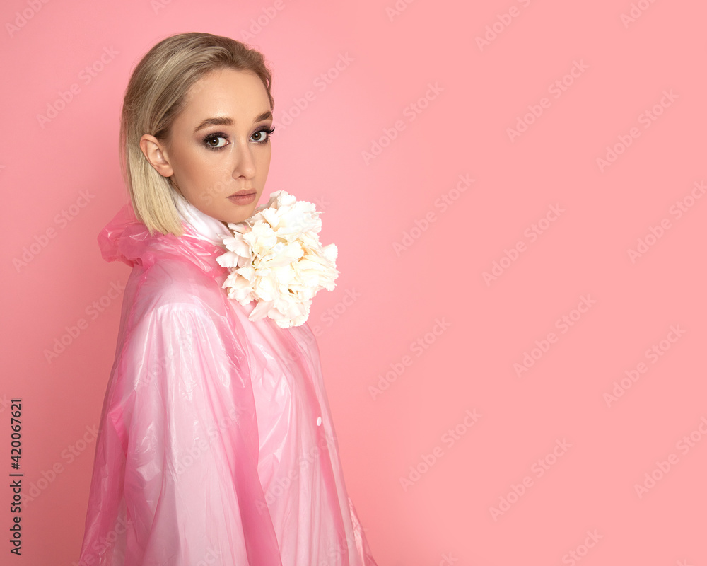 Photo of Beautiful woman with flowers in studio on pink background with blond hair