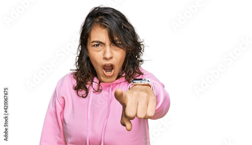 Young hispanic woman wearing casual sweatshirt pointing displeased and frustrated to the camera, angry and furious with you