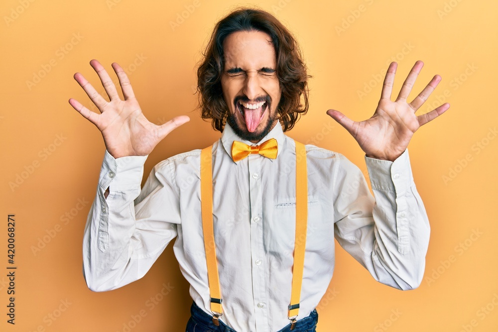 Young hispanic man wearing hipster elegant look celebrating mad and crazy for success with arms raised and closed eyes screaming excited. winner concept Young hispanic man wearing hipster elegant look celebrating mad and crazy for success with arms raised and closed eyes screaming excited. winner concept