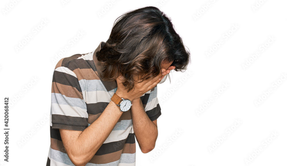 Young hispanic man wearing casual clothes with sad expression covering face with hands while crying. depression concept. Young hispanic man wearing casual clothes with sad expression covering face with hands while crying. depression concept.
