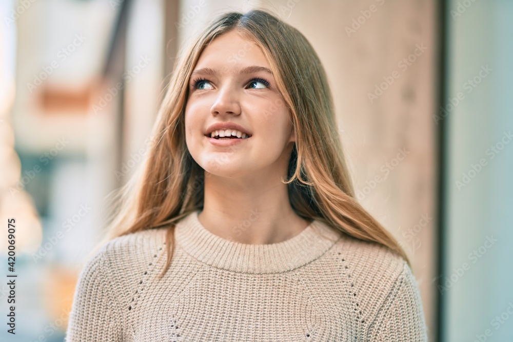 Beautiful caucasian teenager smiling happy standing at the city.
