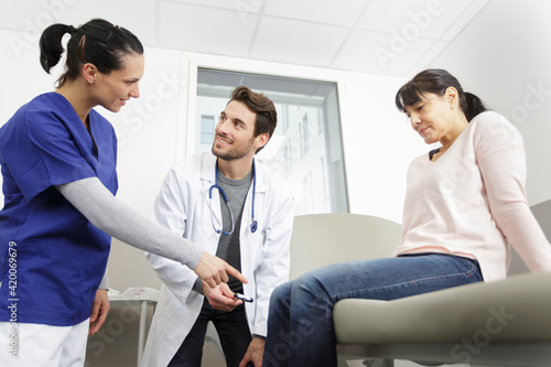 young male doctor checking knee reflexes of female patient