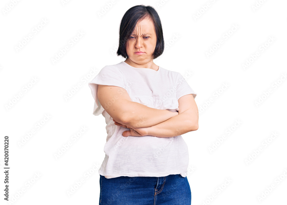 Brunette woman with down syndrome wearing casual white tshirt skeptic and nervous, disapproving expression on face with crossed arms. negative person. Brunette woman with down syndrome wearing casual white tshirt skeptic and nervous, disapproving expression on face with crossed arms. negative person.