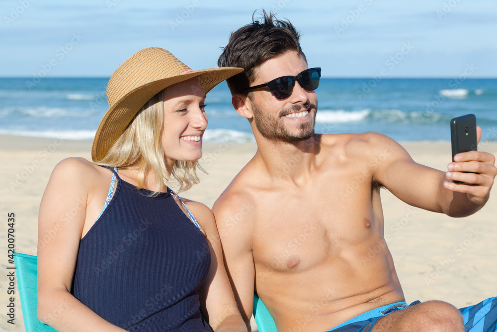 attractive young couple taking selfie on the beach attractive young couple taking selfie on the beach