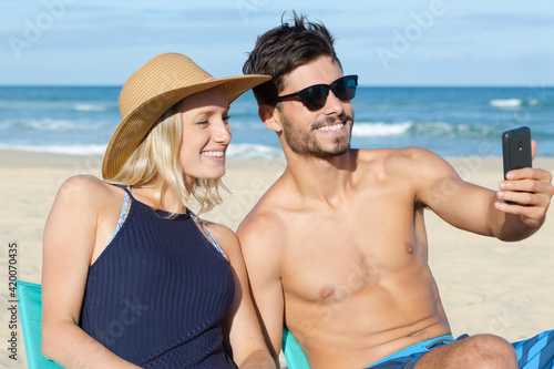 attractive young couple taking selfie on the beach